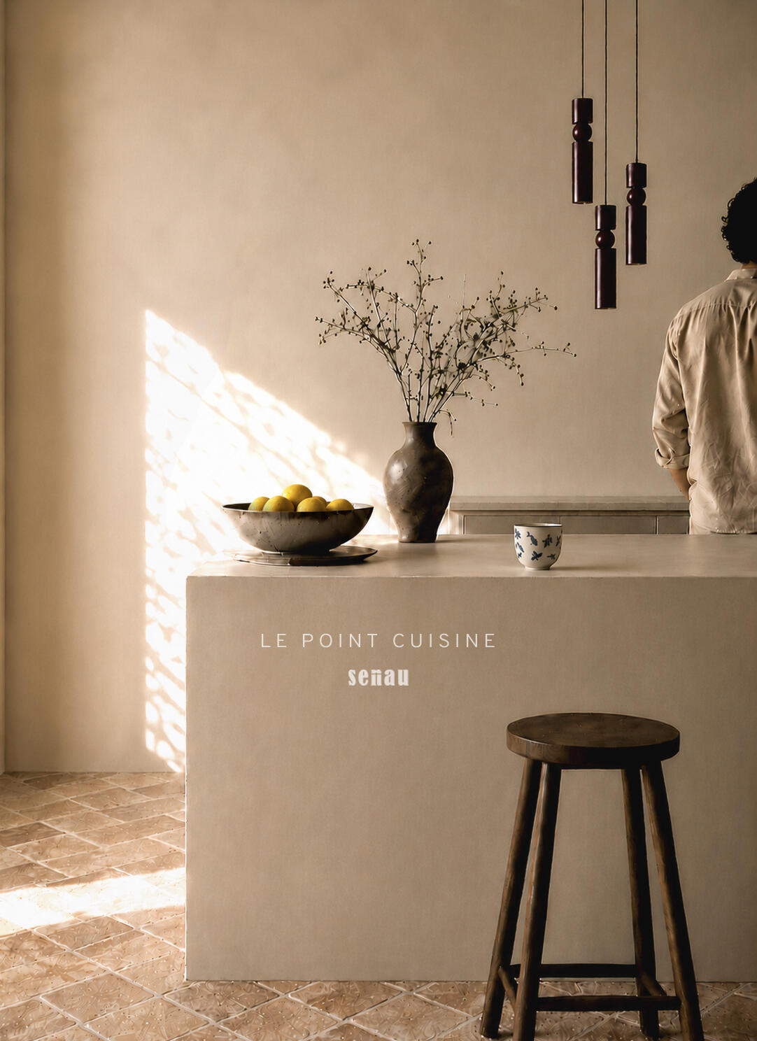 Cuisine épuré avec îlot béton ciré - Le Point Cuisine par Senau Ilot de cuisine en béton ciré baigné de lumière naturelle, sol tomette et suspension en bois foncé. Aix-en-Provence